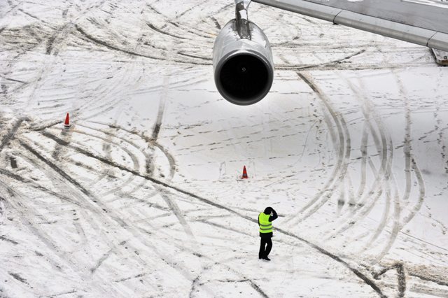 epa01983984 A passenger plane seen at the snow covered tarmac of the international  airport in Frankfurt, Germany, 09 January 2010. Severe winter weather continued to cause havoc across large parts of Europe with snow clogging roads and airports.  EPA/Boris Roessler