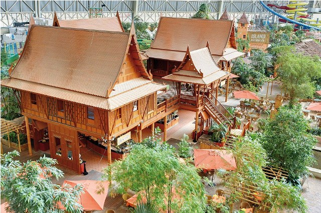 hese are the incredible images of a tropical island paradise INSIDE a building so big could easily fit eight football pitches. A sandy beach, spa, waterfall, whirlpools and water slides are just a few of the attractions inside the old airship hanger. The indoor tropical island, located in Brandenburg, Germany, boasts an air temperature of 26 degrees, with water being 28C in the Tropical Sea and 32 C in the Bali Lagoon. Inside the paradise also host to the worlds biggest indoor rainforest, which features over 50,000 plants and spans over a 10,000 metre square area