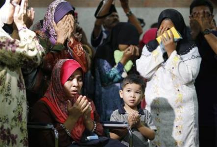 Noraziah Noor and Nurunisa Abu Bakar recite a prayer in Subang