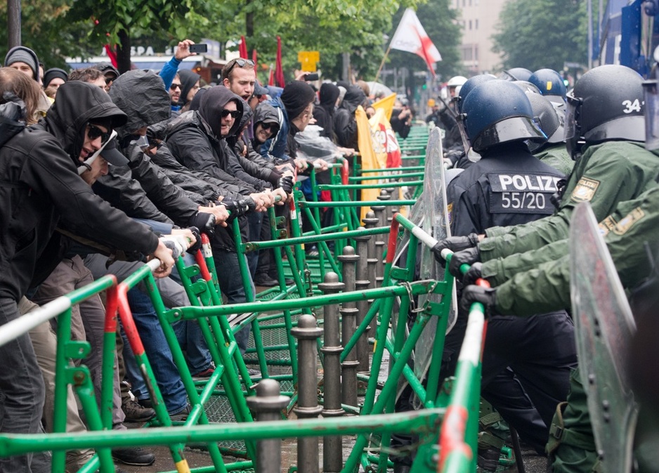 Protesters try to move crash barriers as police stop them outside the European Central Bank (ECB) in Frankfurt am Main, central Germany on May 31, 2013. Anti-globalization protesters are staging two day of demonstrations in the city. AFP PHOTO / BORIS ROESSLER  GERMANY OUT