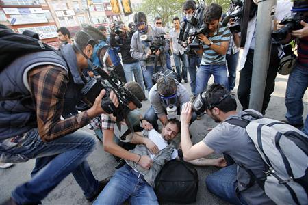 An injured journalist is filmed and helped by his colleagues during clashes between riot police and May Day protesters in central Istanbul