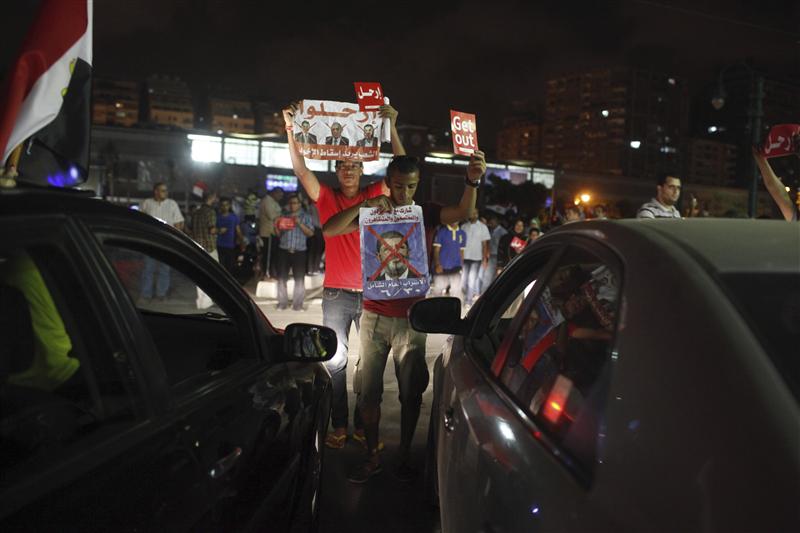 Volunteers from the opposition "Rebel!" campaign stop traffic to campaign for a major protest during the day, in Alexandria