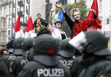 Protesters wave to German riot police during an anti-capitalism "Blockupy" demonstration in Frankfurt