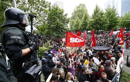 Riot police stand guard in front of protesters during an anti-capitalism "Blockupy" demonstration in Frankfurt