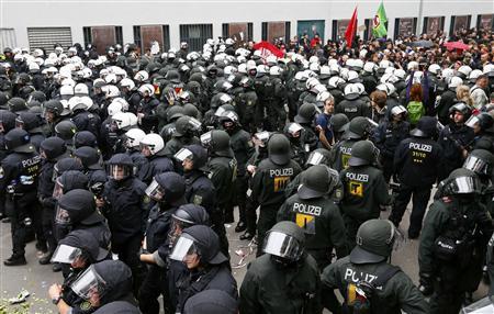 Riot police stand guard in front of protesters during an anti-capitalism "Blockupy" demonstration in Frankfurt