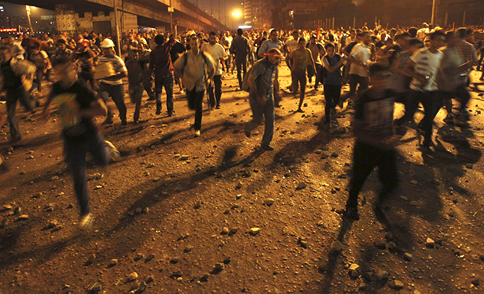Anti-Mursi protesters run during clashes with members of the Muslim Brotherhood and supporters of ousted Egyptian President Mursi near Maspero, near Tahrir square in Cairo