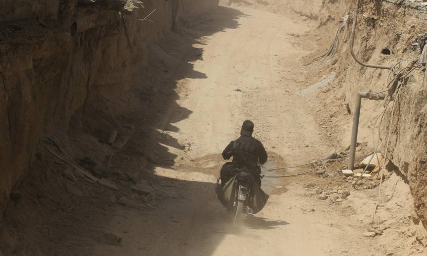 A rebel fighter rides a motorcycle inside a rebel-made tunnel connecting to Zamalka in Jobar, a suburb of Damascus, which activists claim has been undergoing violent clashes between forces loyal to Syria's President Bashar al-Assad and rebel fighters