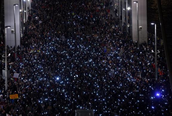 Tens of thousands of Hungarians hold up their mobile phones as they march across the Elisabeth Bridge during a protest against new tax on Internet data transfers in centre of Budapest