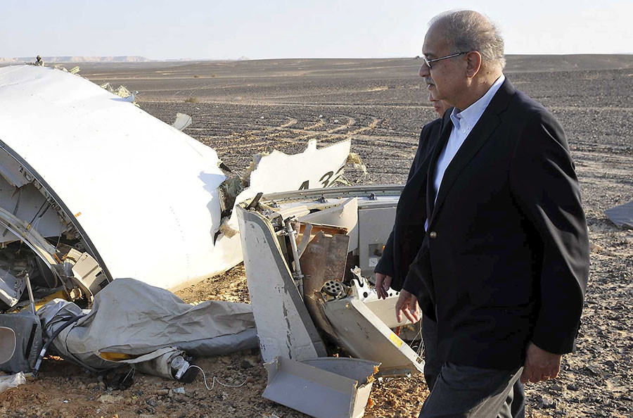 Egypt's Prime Minister Sherif Ismail looks at the remains of a plane crash at the desert in central Sinai near El Arish city